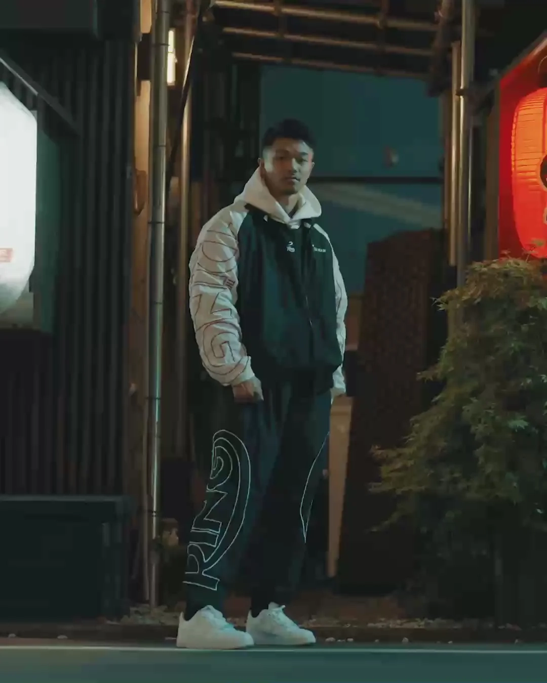 BOXRAW campaign still: a man in a puffer jacket in front of lanterns