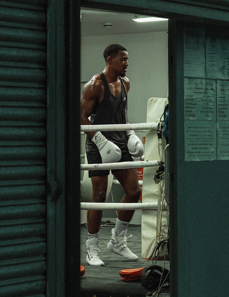A boxer in a doorway at ring-side with a roller shutter behind him