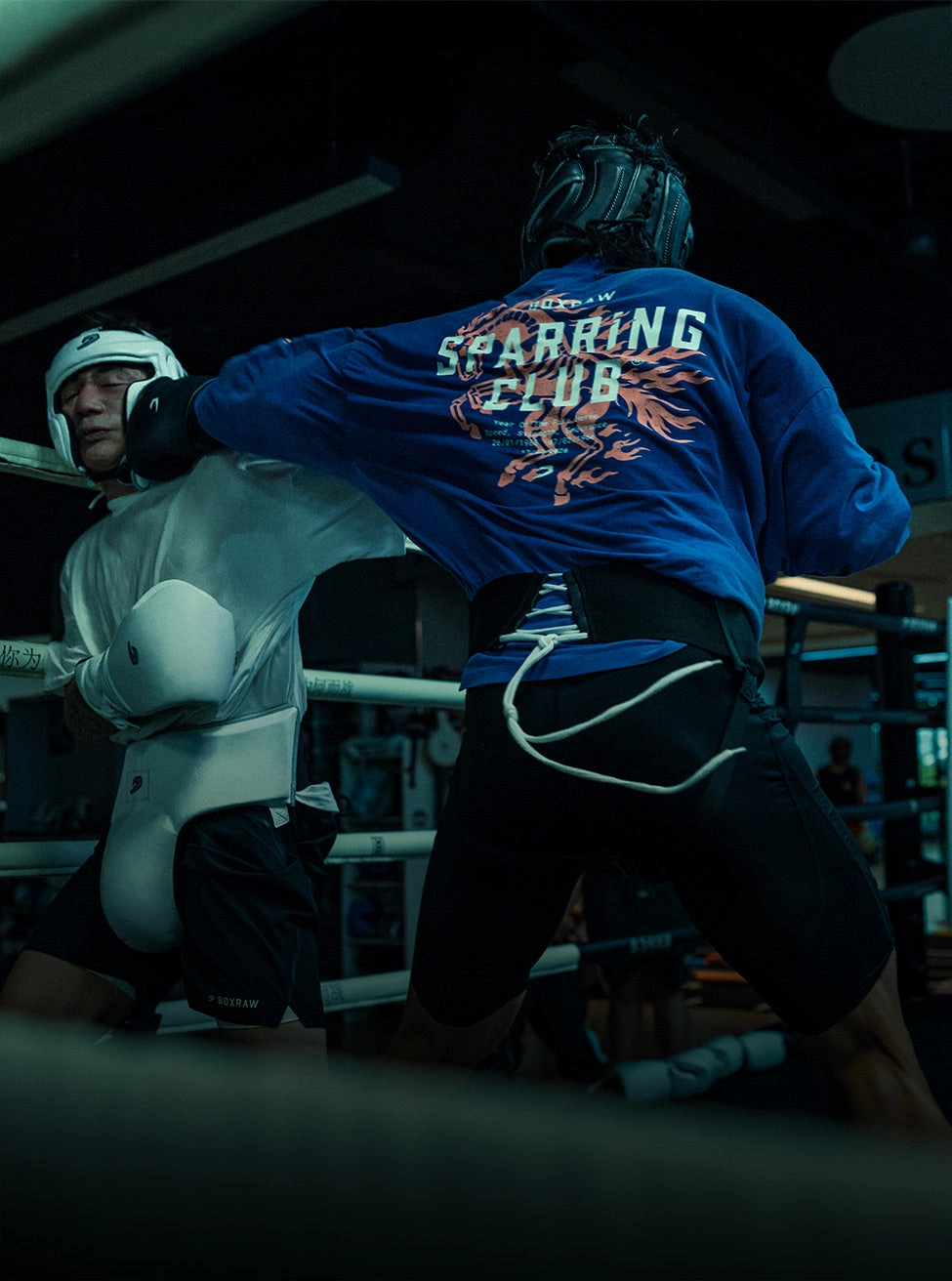 BOXRAW campaign still: a fighter in a blue Sparring Club top in the ring